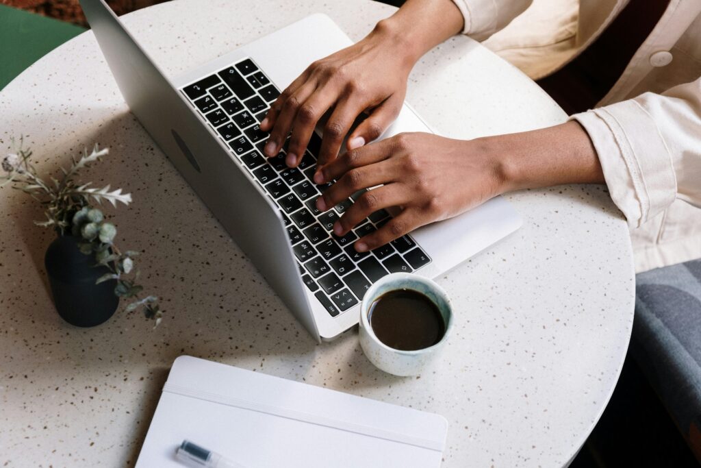 Pisanie blog tekstu na laptopie przy kawie – tworzenie wartościowych wpisów na blogu i treści SEO